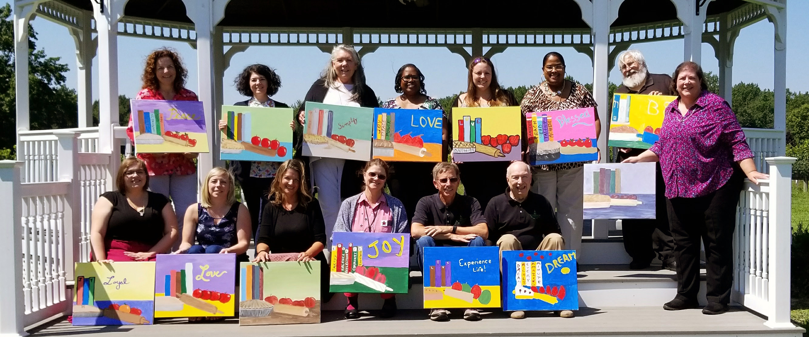 Staff Retreat image of staff with their paintings from an activity