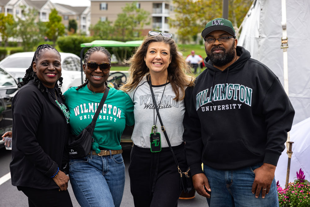 Four students standing and smiling
