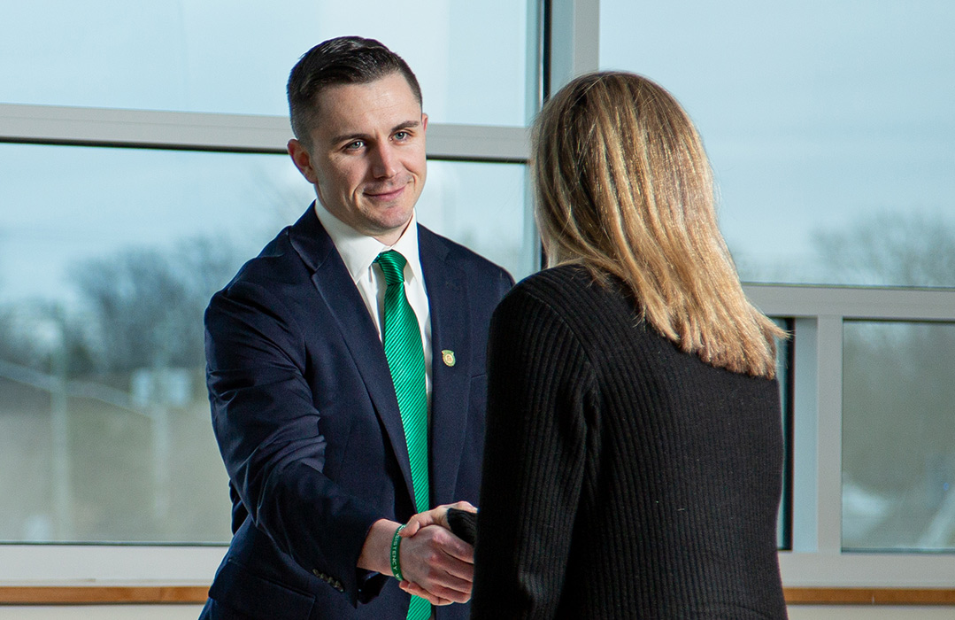 employee shaking hands with a student