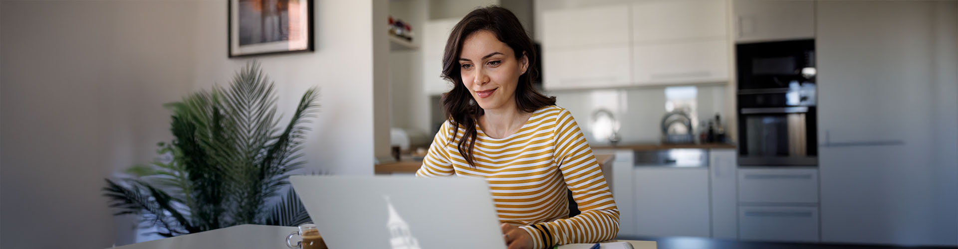 Women sitting at table working on her laptop.