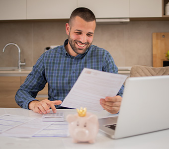 Man smiling while reviewing finances.