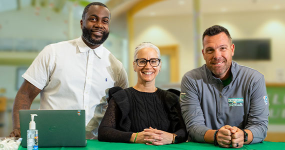 Three Wilmington University employees smiling while at a WilmU event.