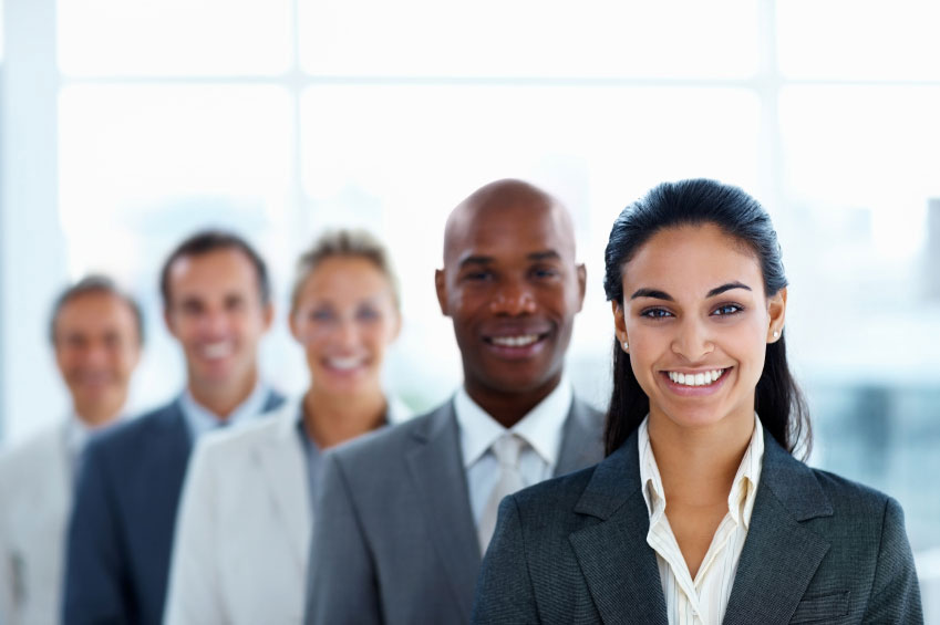 five smiling individuals in business attire