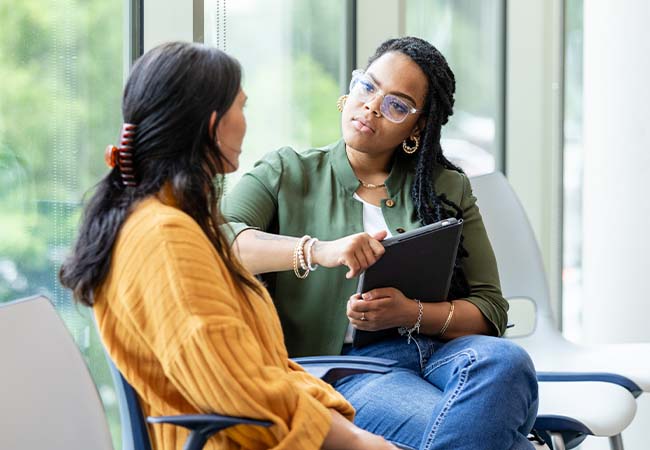 Two Women Discussing Trauma-Informed Approaches