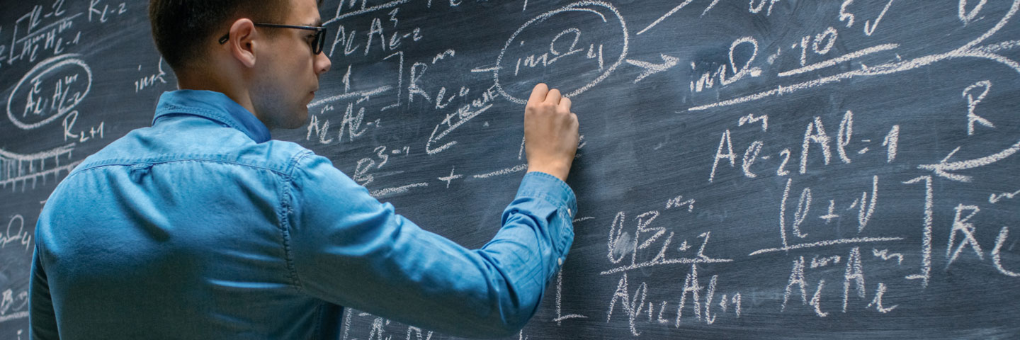 Student writing mathematics on a chalkboard