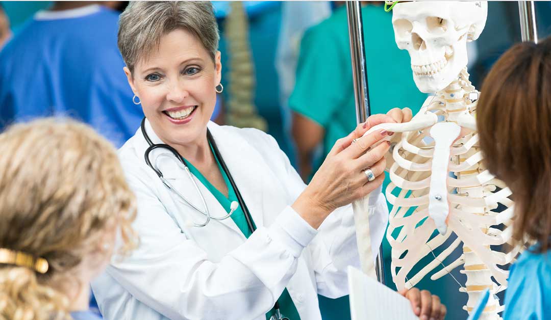 Instructor using skeleton model to teach students