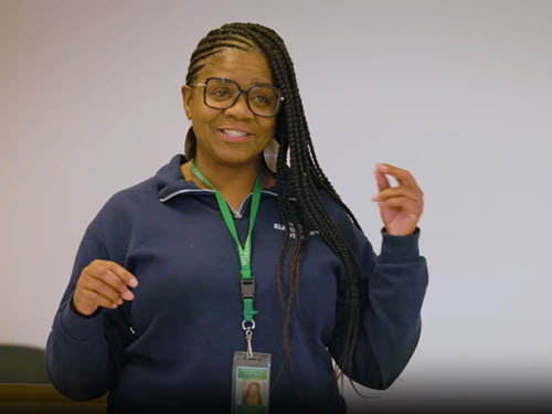 teacher speaking in front of a whiteboard