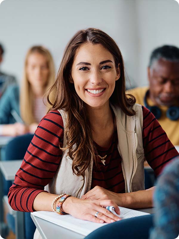Student sitting at desk smiling