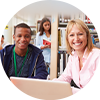 Teacher with student smiling in classroom.