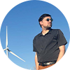 Man standing in front of wind turbine.