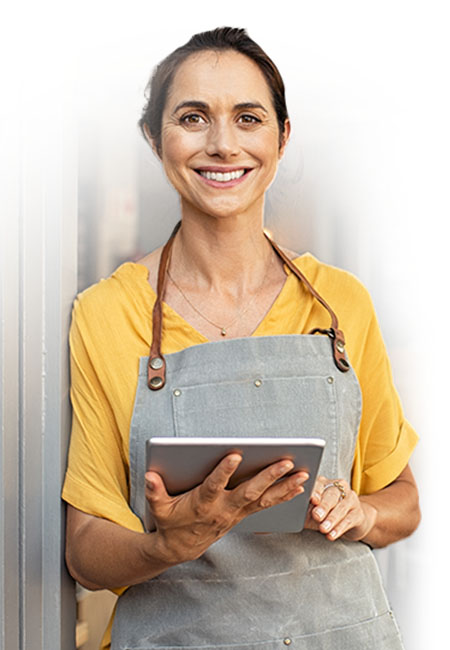 Woman with yellow shirt smiling at the camera holding an ipad