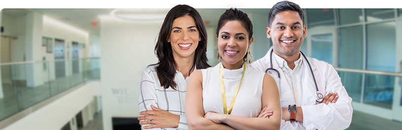 Three medical professionals smiling and standing next to each other