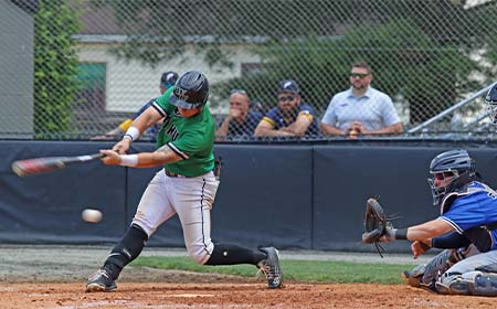 A baseball hitter swings at the pitch as the catcher reaches for the ball